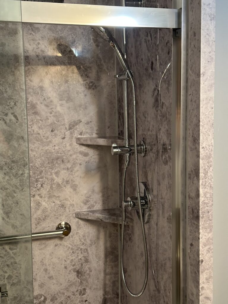 Space-saving corner shower with sliding glass doors and chrome trim in Powell.