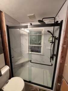 Complete walk-in shower renovation with earth-tone tiles and glass enclosure in Powell.