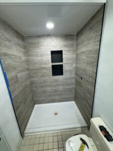 Unique vertical subway tile pattern for a modern shower wall in Columbus.