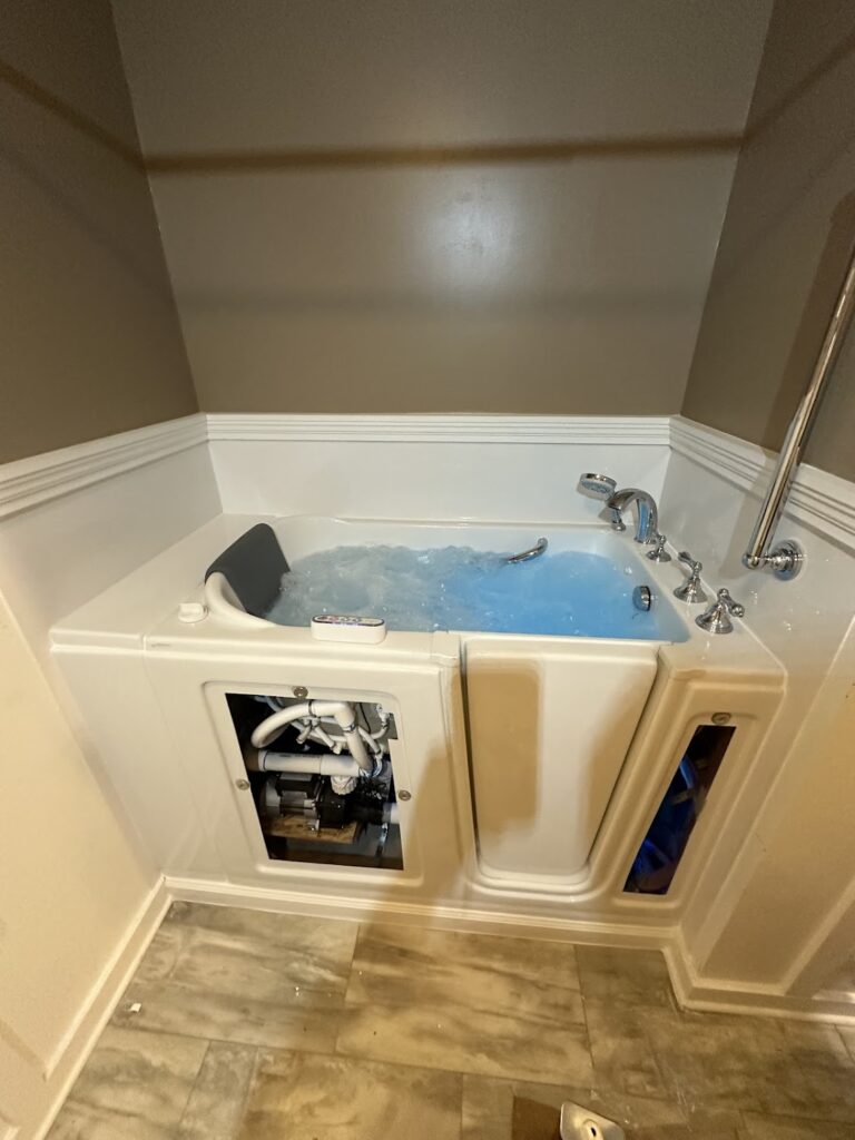 Professional installation of an Ella's Bubbles walk-in tub showing internal motor and plumbing access in Columbus, OH.