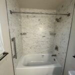 Integrated stone shower shelf for soap and shampoo storage in Powell.