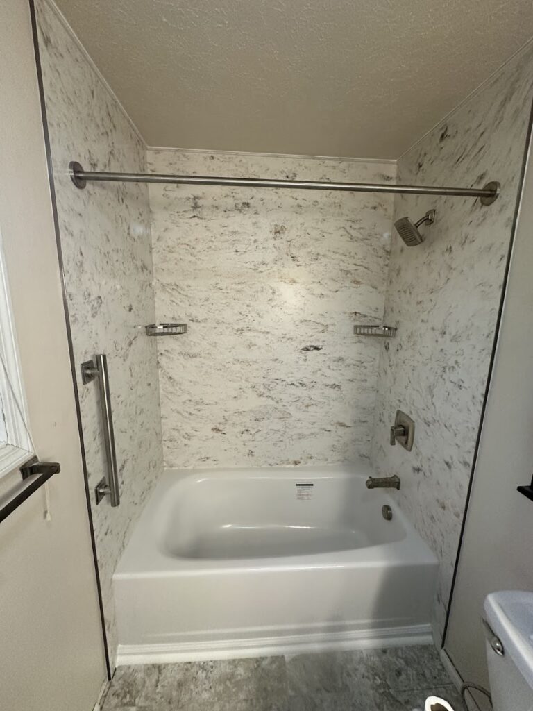 Integrated stone shower shelf for soap and shampoo storage in Powell.