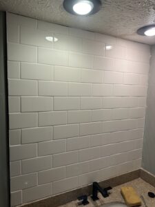 Clean white silicone caulking at the joint of shower walls and base in Dublin.