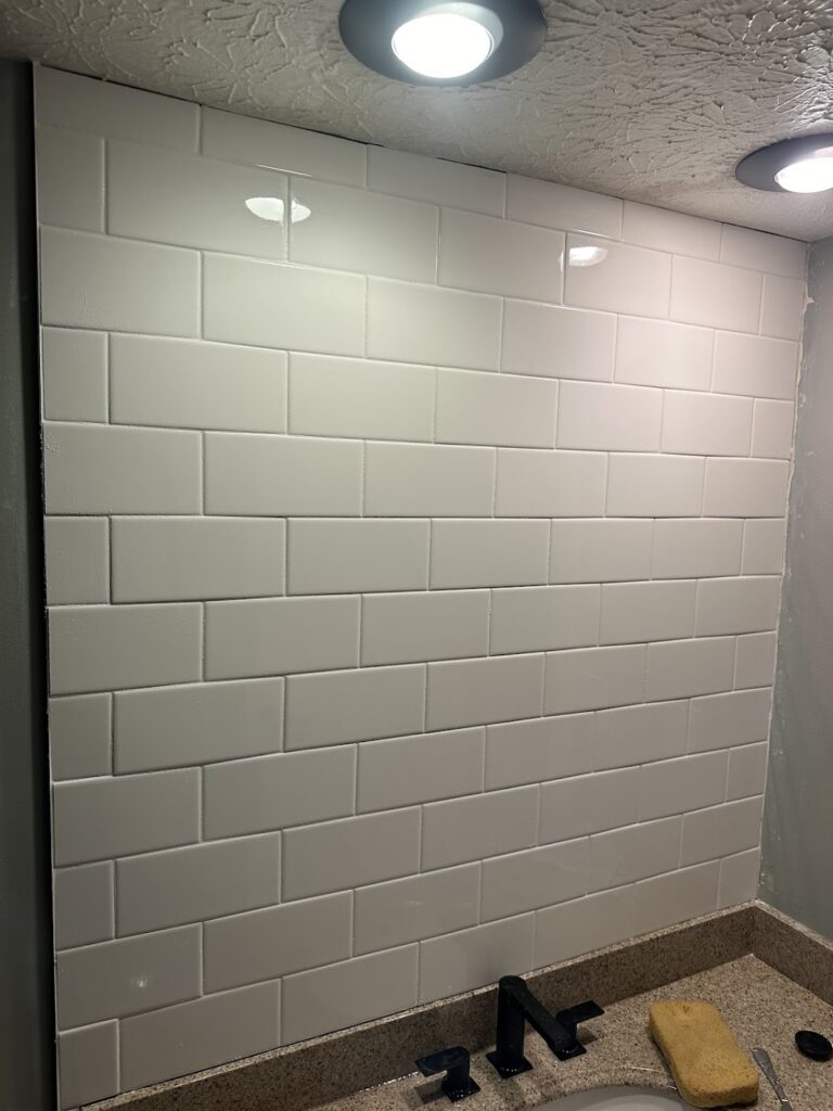 Clean white silicone caulking at the joint of shower walls and base in Dublin.