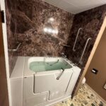 Ella's Bubbles walk-in tub with deep red marble wall surround in Westerville Ohio