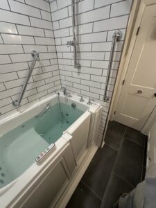 Professional walk-in tub installation featuring white subway tile walls and multiple chrome safety grab bars in Powell, OH.