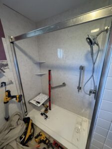 Stainless steel vertical safety grab bar installed next to shower controls in Dublin, OH.