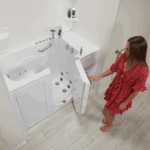 Woman opening an outward swing door of a white luxury walk-in bathtub with hydrotherapy jets.