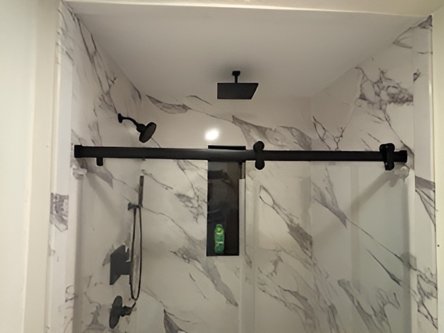 Pickerington bathroom remodel with marble shower walls and matte black sliding door