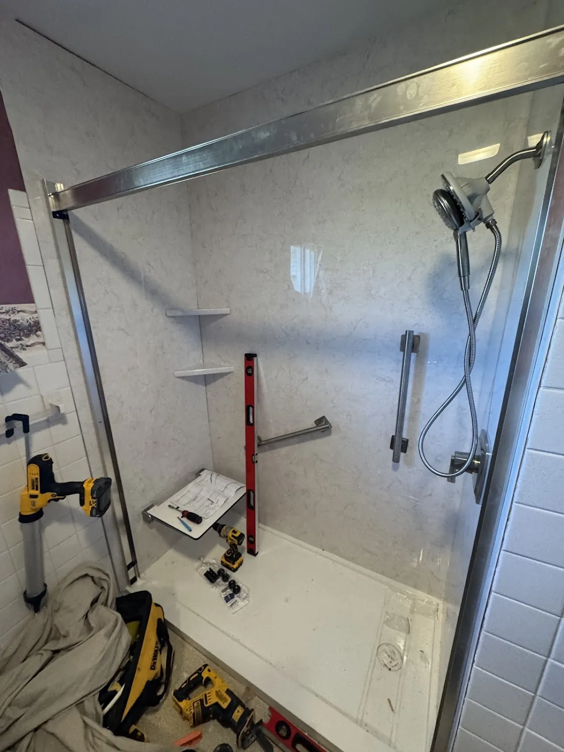 Stainless steel vertical safety grab bar installed next to shower controls in Dublin, OH.